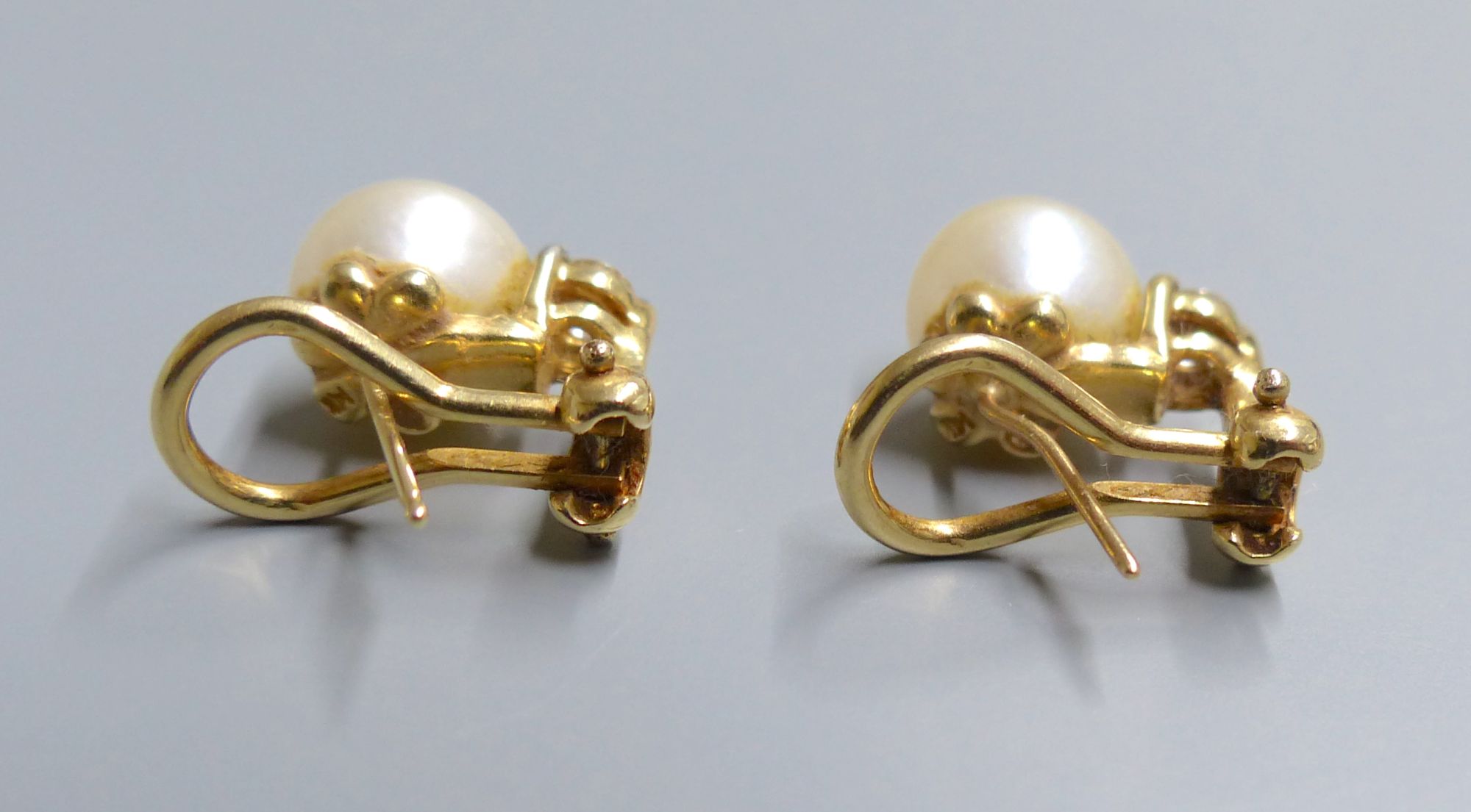 A modern pair of 14k, cultured pearl and diamond set earclips, gross 5.1 grams,